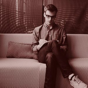 Man Sitting on Sofa Writing